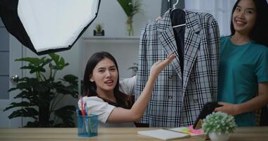 Jeune magnifique asiatique femme vivre diffusion à vêtements magasin photo