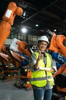 portrait de femelle ingénieur avec le mission de audit, essai, amélioration Logiciel et calibrer la robotique bras. photo