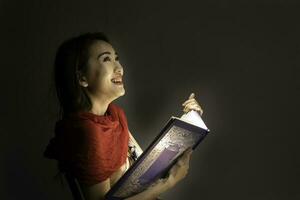 asiatique femme ouverture mystique livre boîte magique lumière foncé Contexte photo