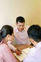 Jeune Sud est asiatique milieu est homme femme affaires collègue Extérieur café chaise table réunion parlant discuter fichier papier photo