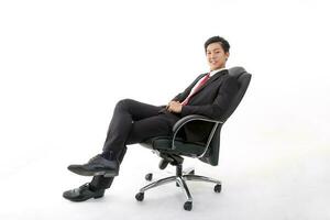 asiatique Jeune chinois homme portant formel affaires Bureau vaisselle sur blanc Contexte séance sur Bureau chaise se détendre pense Succès content inquiet photo