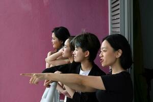 Jeune sud-est asiatique femme groupe sur balcon véranda permanent côté par côté profiter vue parlant content à la recherche photo