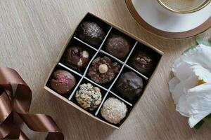 Chocolat artisanat des sucreries dans boîte avec café et fleur sur table Haut voir, plat allonger photo