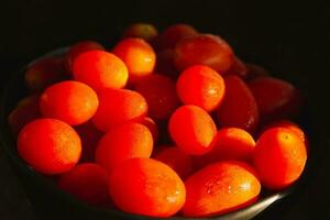 rouge petit Cerise tomates avec laissez tomber de l'eau Contexte. photo