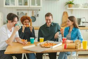 Accueil faire la fête. fou de joie diverse copains en mangeant commandé Pizza pour Accueil faire la fête. content groupe mixte course Jeune copains profiter dépenses gratuit fin de semaine temps ensemble ayant amusement en riant plaisanterie communicant. photo