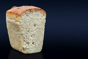 seigle pain sur une foncé Contexte dans le Couper avec une croustillant croûte et texture dans le trou. Frais Accueil cuit levain pain. photo dans haute qualité