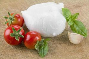 Mozzarella bio italienne aux tomates cerises et basilic sur une planche à découper