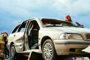 sapeurs pompiers pendant une porter secours opération formation dans cassé voiture photo