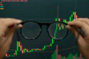 main en portant des lunettes Commerce financier les stocks et investissements photo