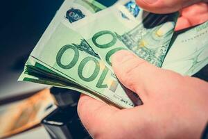 Hommes compte le sien gains dans euro billets de banque photo