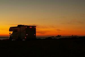 scénique océan rive le coucher du soleil et campeur van classe c RV photo