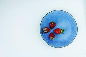 mûr rouge des fraises dans une bleu assiette photo