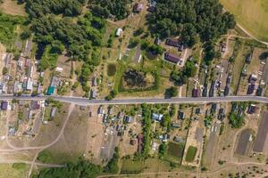 panoramique aérien vue de éco village avec en bois Maisons, gravier route, jardins et vergers photo