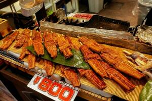 géant Japonais grillé anguilles poisson pour vente avec Japonais prix étiquette à kuromon ichiba marché, Osaka, Japon. Japonais grillé anguilles poisson sont luxe et coûteux de Japonais aliments. photo