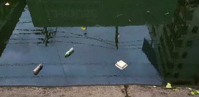 Bangkok, thaïlande-avril 17, 2023 beaucoup ordures, Plastique bouteilles, Plastique Sacs, feuilles, nourriture restes et papier flottant dans rivière ou canal. l'eau pollution, ordures. eaux usées, saleté et nettoyer monde. photo