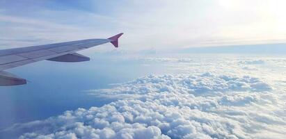 aérien vue de avion ou avion aile en volant sur ciel et magnifique blanc des nuages et copie espace. en voyageant, doux de nuageux, beauté de la nature à hauteurs concept photo