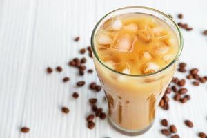 Café glacé dans un verre sur un fond en bois blanc photo