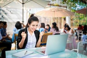 Jeune femme d'affaires occupée travaillant dans un café en plein air photo