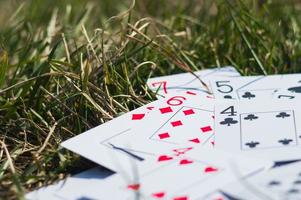 cartes à jouer dans l'herbe verte se bouchent photo