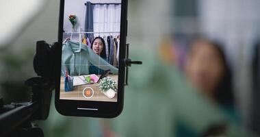 Jeune asiatique femelle mode designer en utilisant mobile téléphone vivre fumant photo