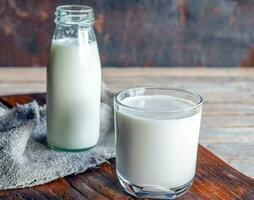 bouteilles et verres à lait sur une table en bois photo