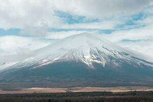 scénique vue de enneigé Montagne Fuji contre ciel à yamanaka Lac photo