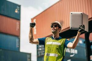 ingénieur Dock ouvrier dans protecteur sécurité combinaison uniforme et avec casque et utilisation portable ordinateur à cargaison récipient livraison entrepôt. transport Importer / Exporter la logistique industriel photo