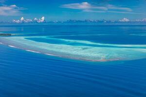 îles tropicales et atolls aux maldives depuis une vue aérienne. destination de voyage célèbre et concept de vacances de luxe ou de vacances d'été. paysage aérien de la mer bleue et des stations balnéaires, hôtels. belle nature photo