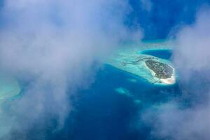 îles tropicales et atolls aux maldives depuis une vue aérienne. destination de voyage célèbre et concept de vacances de luxe ou de vacances d'été. paysage aérien de la mer bleue et des stations balnéaires, hôtels. belle nature photo