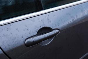 poignée de porte de voiture avec gouttelettes d'eau ou de pluie photo