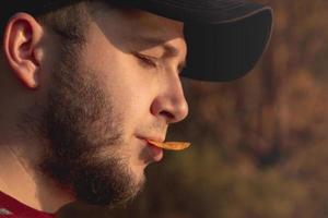 homme barbu dans la forêt, manger des chips photo