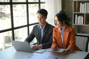 asiatique affaires collègue affaires présente et explique et en utilisant portable et tablette. travail en équipe, financier commercialisation équipe, tandis que séance dans Bureau chambre. photo