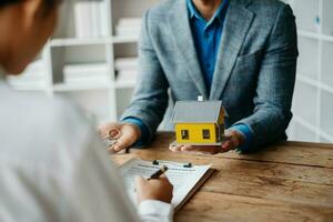 une famille couple signe une bail réunion avec une agent immobilier ou propriétaire, achat le premier hypothèque et hypothèque la possession concept. photo