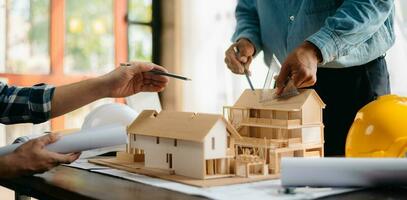 deux architectes discuter Nouveau projet. Jeune Hommes et femmes travail ensemble à forme une Nouveau bâtiment. photo