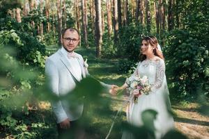 photo de mariage des mariés dans une couleur gris rose sur la nature dans la forêt et les rochers