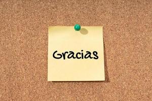 Gracias - mot de remerciement en langue espagnole sur note jaune en panneau de liège