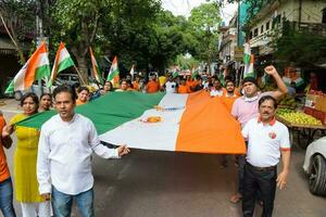 Delhi, Inde -15 mai 2023 - grand groupe de gens pendant gros tiranga yatra organisé comme partie de le azadi ka amrit mahotsav à célébrer le 76 anniversaire de l'Inde indépendance, Indien drapeau Mars photo