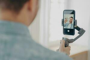 beau jeune homme brunete souriant avec chaume faisant selfie sur smartphone photo