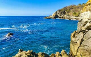 surfeur vagues turquoise bleu l'eau rochers falaises rochers puerto escondido. photo