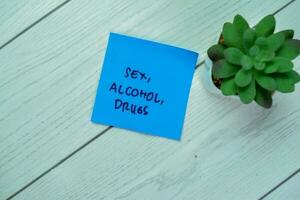 concept de sexe, alcool, drogues écrire sur gluant Remarques isolé sur en bois tableau. photo