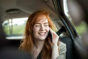 Jeune fille les usages une mobile téléphone dans le auto. La technologie cellule téléphone isolement. l'Internet et social médias. femme avec téléphone intelligent dans sa auto. fille est en utilisant une téléphone intelligent dans voiture photo