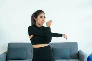 asiatique Jeune en bonne santé femme dans articles de sport pratiquant yoga à maison, sport fille exercice dans vivant pièce à Accueil photo