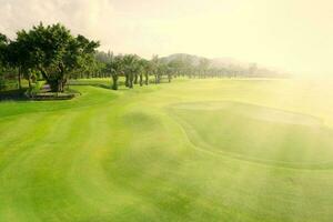 magnifique le golf cours vue avec Soleil des rayons, le golf cours avec magnifique en mettant vert, Frais vert herbe sur le le golf cours photo