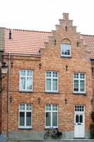 vélo et traditionnel Maisons à le historique ville de Bruges photo