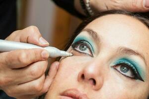 maquillage artiste nettoyage et donnant le final touche à chat yeux maquillage photo