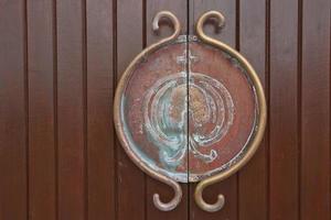 Poignée en métal médiéval et poignée de porte sur une porte en bois photo