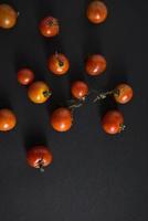 tomates cerises à plat sur fond noir photo