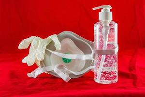 Gel désinfectant gants en latex blanc et masque sur le concept de protection rouge contre le virus de la pollution, la grippe et le coronavirus photo