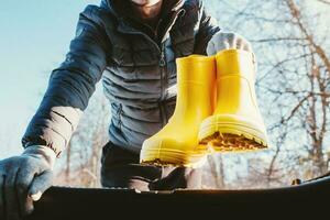 chargement dans le tronc de Jaune caoutchouc bottes pour en marchant sur humide sol et herbe - une voyage à choisir champignons et baies photo