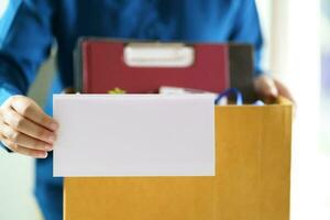 quitter emploi affaires homme Envoi en cours démission lettre et emballage des trucs démissionner déprimer ou porter affaires papier carton boîte dans bureau. changement de emploi ou mis à la porte de entreprise. photo